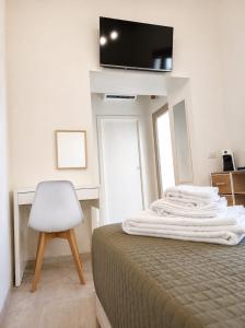 a bedroom with a bed and a chair and a television at Marconi 306 in Quartu Sant'Elena