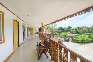 a balcony with a bench and a view of the street at Reaunnapa Resort in Ban Nong Kham