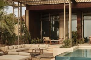 a living room with a couch and a swimming pool at Rosewood AMAALA in Amala +14 photos