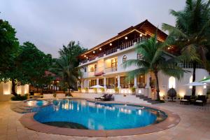 a hotel with a swimming pool in front of a building at Golden Tulip Goa Mandrem in Mandrem