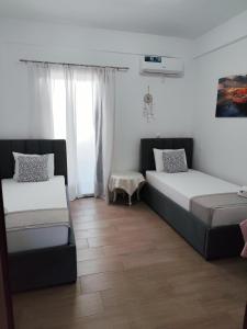 a bedroom with two beds and a window at M&J Home in Ksamil +90 photos