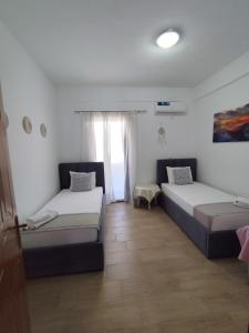 a bedroom with two beds and a window at M&J Home in Ksamil