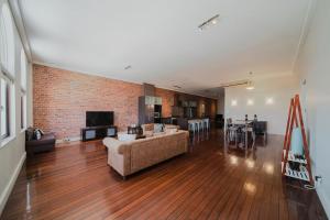a large living room with a couch and a kitchen at Flinders 2 bed apartment near the Strand in Townsville