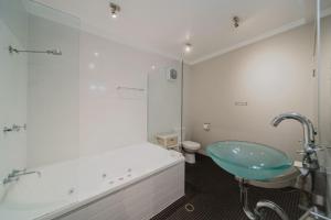 a bathroom with a sink and a glass shower at Flinders 2 bed apartment near the Strand in Townsville +15 photos