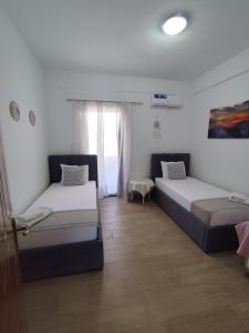 a bedroom with two beds and a window at M&J Home in Ksamil