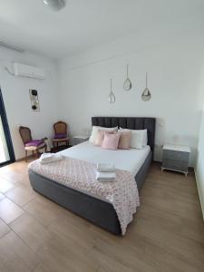 a bedroom with a large bed with pink pillows at M&J Home in Ksamil