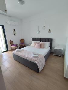 a bedroom with a large bed with pink pillows at M&J Home in Ksamil