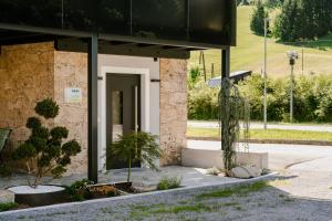 a building with a door and some plants in front of it at Peak9 Apartment in Greifenburg