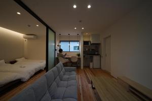 a bedroom with a large bed and a man sitting in a chair at 紀の川みんと間 in Kinokawa
