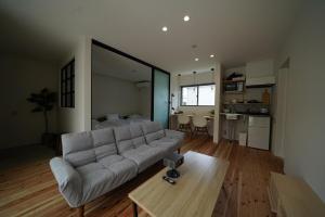 a large living room with a couch and a kitchen at 紀の川みんと間 in Kinokawa