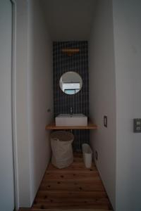a bathroom with a sink and a mirror on a wall at 紀の川みんと間 in Kinokawa