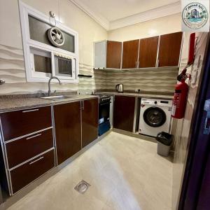 a kitchen with a sink and a washing machine at المنصور 3 in Salalah