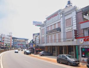 a city street with cars parked in front of buildings at The Hotel Chettungal in Angamaly +16 photos