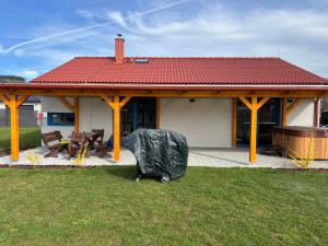 a house with a covered porch with a grill at Chalupa Postřekovo in Postřekov