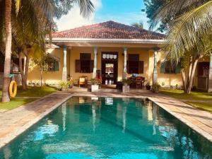 a house with a swimming pool in front of a house at Villa Sethawadi Hotel and Kitesurf Centre in Kalpitiya