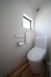 a white bathroom with a toilet and a window at 紀の川みんと景 in Kinokawa +21 photos