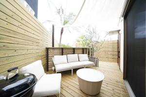 a balcony with white chairs and a bath tub at 紀の川みんと景 in Kinokawa