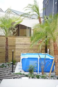 a blue table and palm trees in a yard at 紀の川みんと景 in Kinokawa