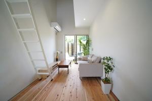 a living room with a staircase and a couch at 紀の川みんと景 in Kinokawa