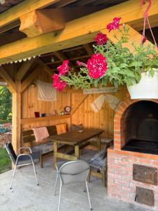a patio with a fireplace with a table and flowers at ReziPáva Blue in Zăbala