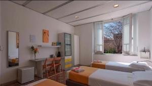 a room with two beds and a desk and a window at Lungomare Casa Diaz in Cagliari