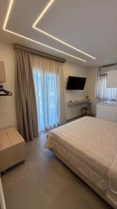 a bedroom with a bed and a flat screen tv at Villa Kostas Sarti in Sarti