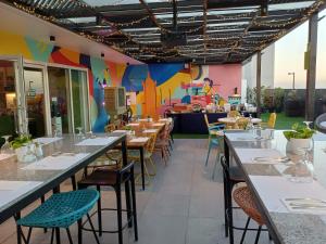 a restaurant with tables and chairs and a colorful wall at lyf Malate Manila managed by The Ascott Limited in Manila
