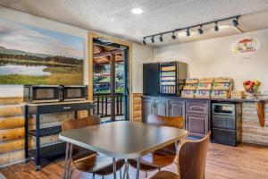 a kitchen with a table and a table and chairs at Super 8 by Wyndham Cody in Cody