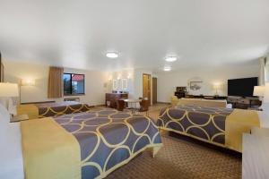 a hotel room with two beds and a flat screen tv at Super 8 by Wyndham Cody in Cody