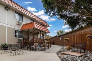 a patio with chairs and tables in front of a house at Super 8 by Wyndham Cody in Cody