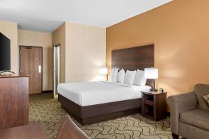 a hotel room with a bed and a couch at Days Inn by Wyndham Columbia Mall in Grand Forks +50 photos