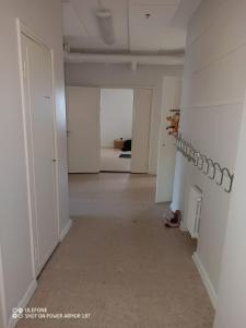 an empty white room with a bed and a hallway at Tattara School Room 2 in Nakkila