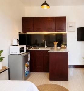 a kitchen with brown cabinets and a white refrigerator at Kivulini Homes in Arusha