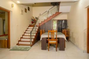 a dining room with a table and a staircase at The Grand Villa Kochi in Cochin