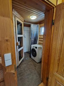 a bathroom with a washing machine in a room at Honkaranta Cottage in Jämsä