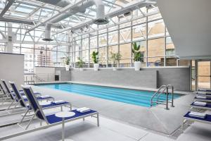 a swimming pool in a building with chairs and tables at Hyatt Regency Washington on Capitol Hill in Washington, D.C.