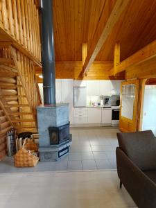 a living room with a stove in a room with wooden ceilings at Honkaranta Cottage in Jämsä +7 photos