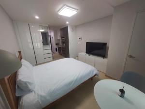 a bedroom with a bed and a table and a television at Guri 365 Stay in Guri