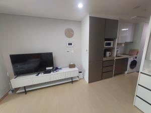 a living room with a large flat screen tv at Guri 365 Stay in Guri