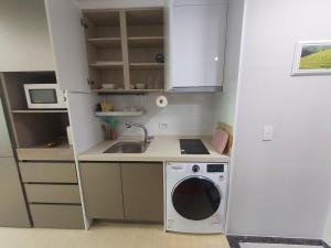 a kitchen with a washing machine and a sink at Guri 365 Stay in Guri +15 photos