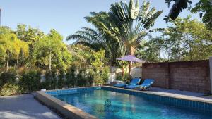 una piscina con 2 sillas y una sombrilla en The Retreat Ao nang Private Pool Villa, en Ao Nang Beach