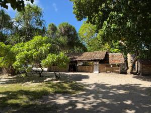 a small wooden building with a straw roof at Twin Beach Bungalows in Loh