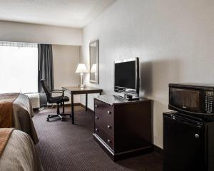 a hotel room with a bed and a desk with a television at Comfort Inn & Suites Lumberton Central I-95 in Lumberton