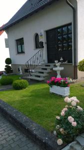 una casa con un patio con flores y una fuente en Ferienwohnung Dernbecher, en Saarbrücken