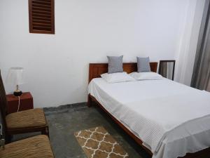 a bedroom with two beds and a table and a lamp at The Grand Villa Malabe in Malabe