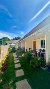 a house with a pathway next to a fence at R&A Haven Guest House in San Juan