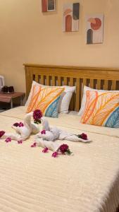 two stuffed animals on a bed with flowers on it at R&A Haven Guest House in San Juan