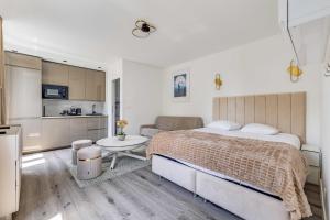 a bedroom with a large bed and a kitchen at Cozy Studio 4P - Aubervilliers in Aubervilliers