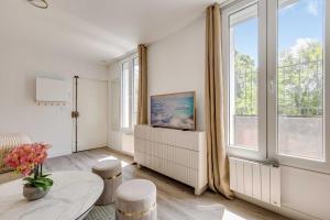 a living room with a table and a large window at Cozy Studio 4P - Aubervilliers in Aubervilliers