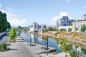a view of a river in a city with buildings at Cozy Studio 4P - Aubervilliers in Aubervilliers